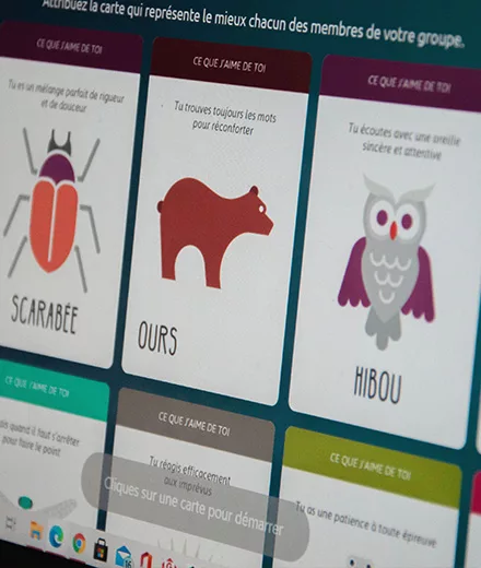 Écran d’ordinateur affichant des cartes illustrées représentant des qualités humaines (scarabée, ours, hibou), utilisées pour valoriser les forces individuelles dans un feedback stratégique.