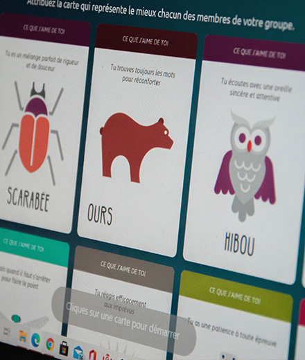 Écran d’ordinateur affichant des cartes illustrées représentant des qualités humaines (scarabée, ours, hibou), utilisées pour valoriser les forces individuelles dans un feedback stratégique.