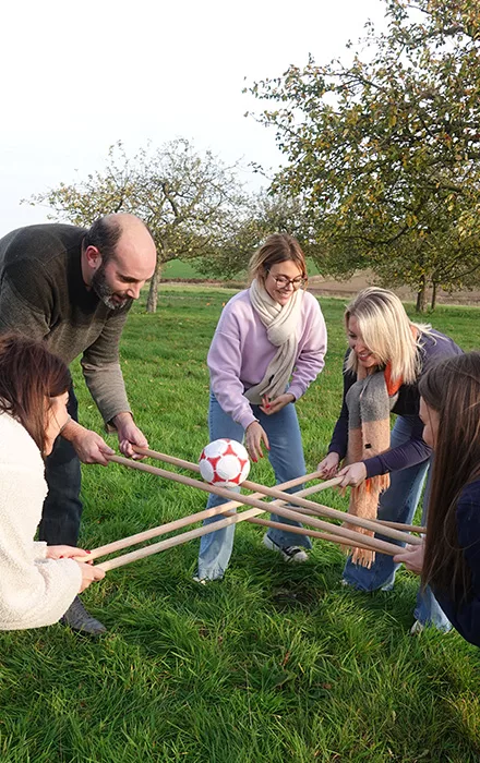Vision fun d'un
team building Team First dans un paysage vert